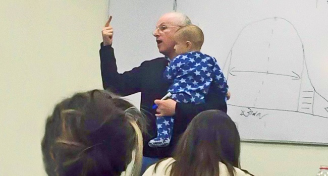 Profesor drži predavanje s djetetom u naručju